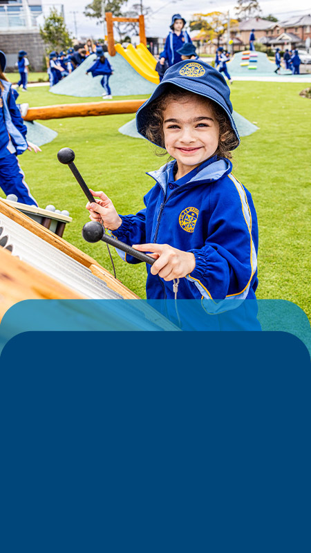 Student playing a drum in the playground at Our Lady Queen of Peace Primary School Greystanes