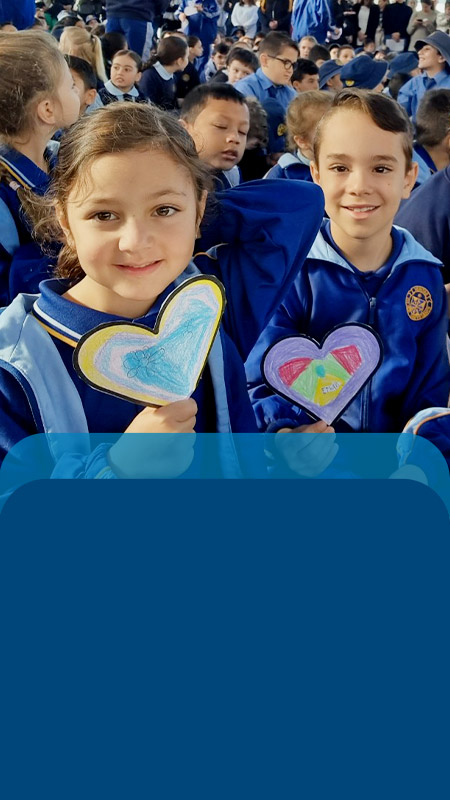 Students holding love heart artwork at assembly at Our Lady Queen of Peace Primary School Greystanes