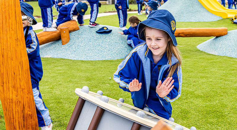 Student playing the drum in the playground at Our Lady Queen of Peace Primary School Greystanes