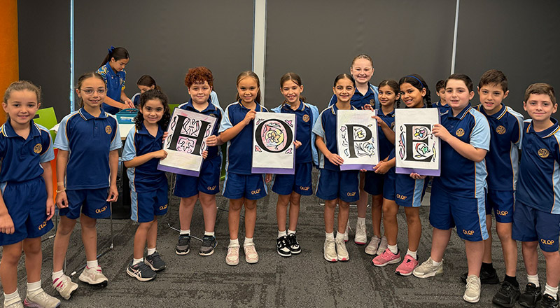 Students holding letters spelling 'HOPE' suring a religion class at Our Lady Queen of Peace Primary School Greystanes