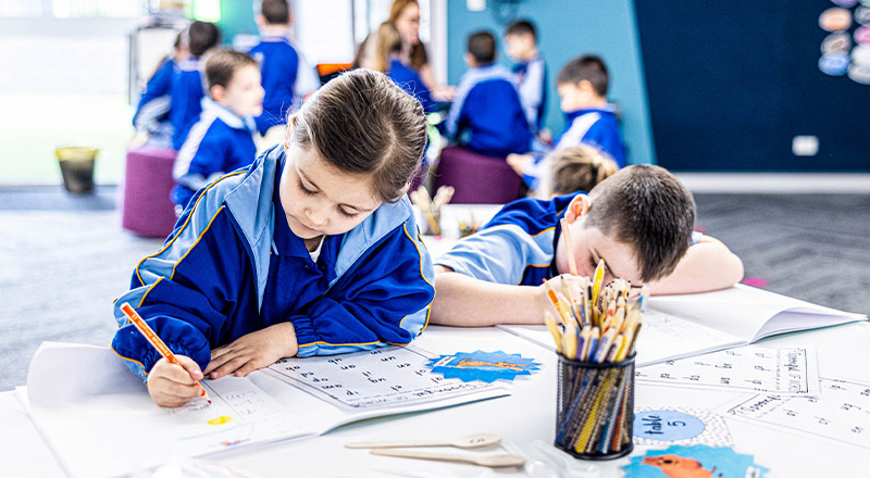 Students writing in the classroom at Our Lady Queen of Peace Primary School Greystanes