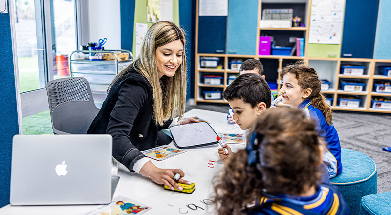 Teacher reading with her students in the classroom at Our Lady Queen of Peace Primary School Greystanes