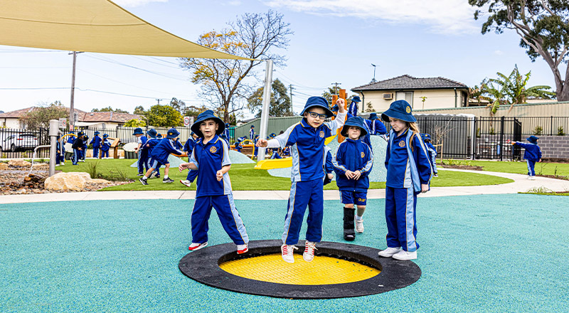 Students jumping on the trampoline in the playground at Our Lady Queen of Peace Primary School Greystanes