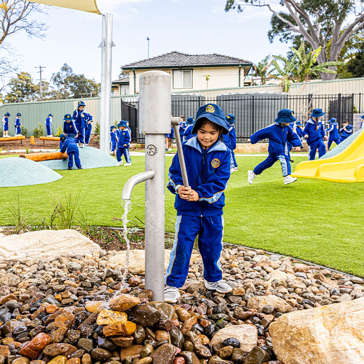 Student playing in water in the playground at Our Lady Queen of Peace Primary School Greystanes