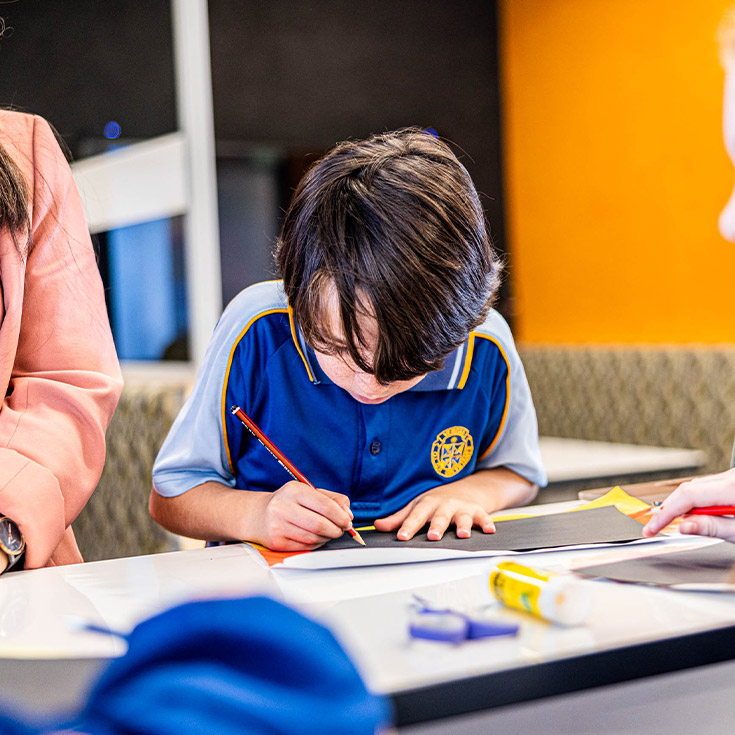 Student writing in the classroom at Our Lady Queen of Peace Primary School Greystanes