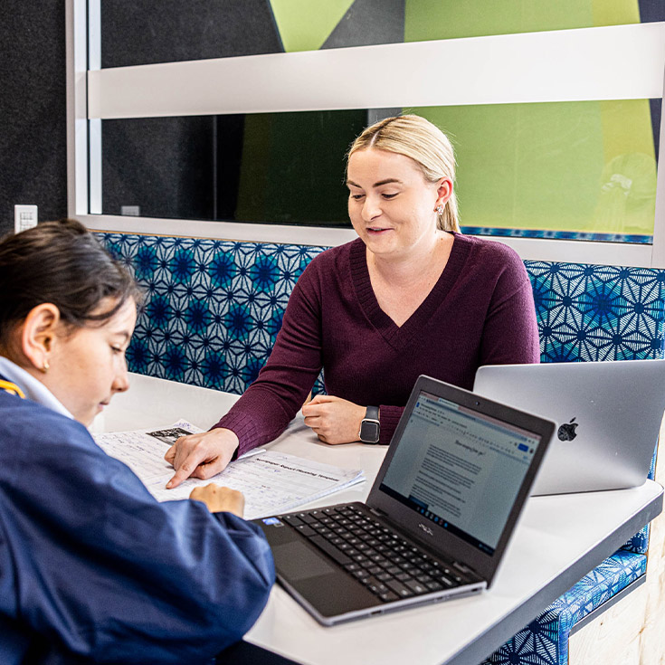Teacher reading with her student in the classroom at Our Lady Queen of Peace Primary School Greystanes