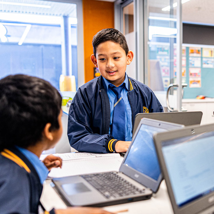 Students speaking to each other in the classroom at Our Lady Queen of Peace Primary School Greystanes